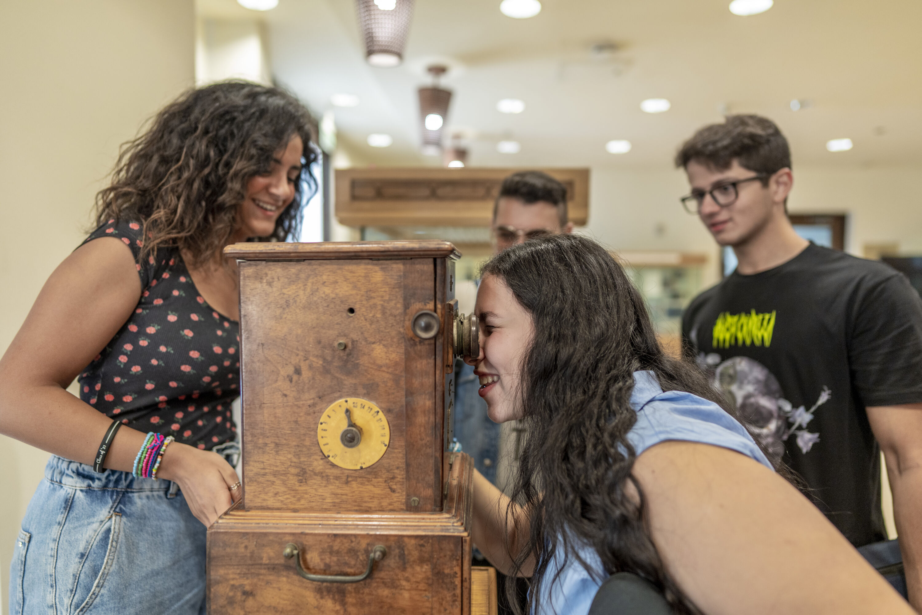 Students looking into an old wooden camera