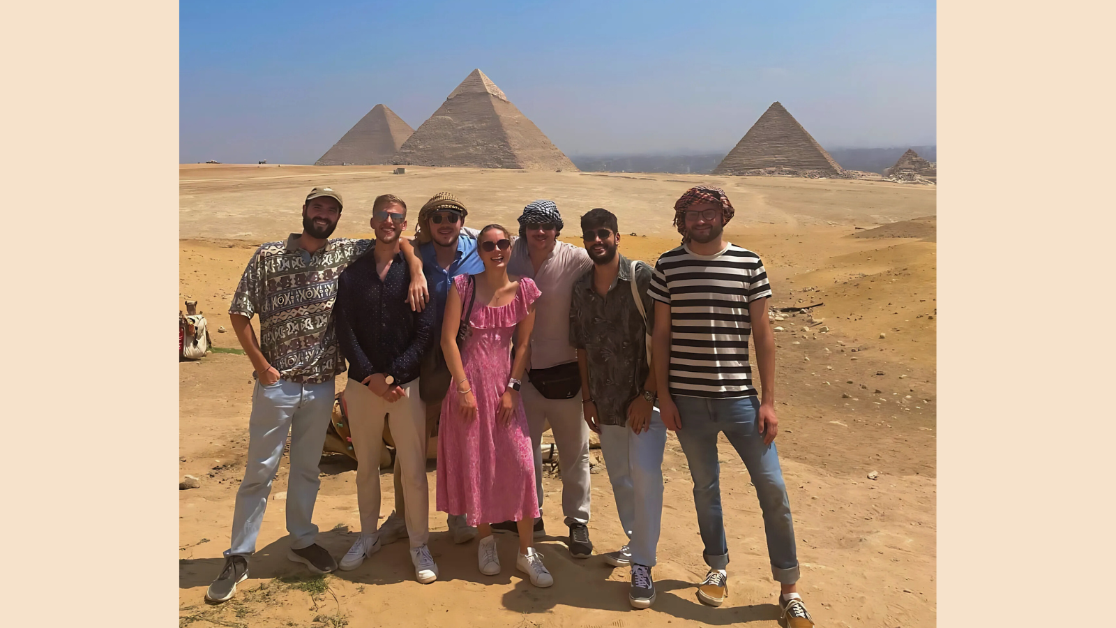 The CMEPS cohort (seven students) smiles in front of the Pyramids of Giza.