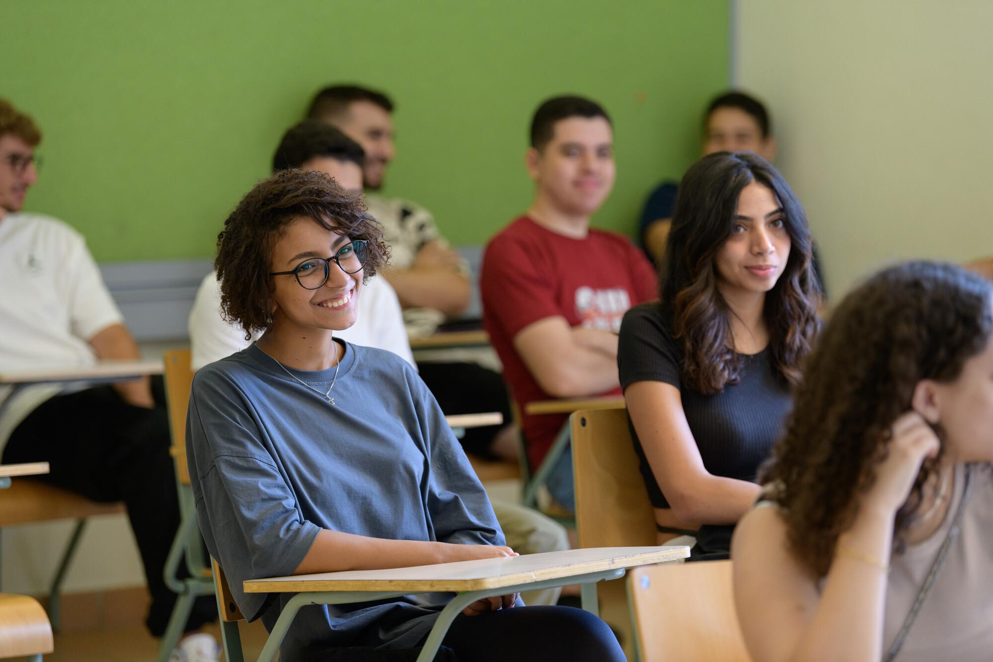 students in class room smiling and focusing on lecture