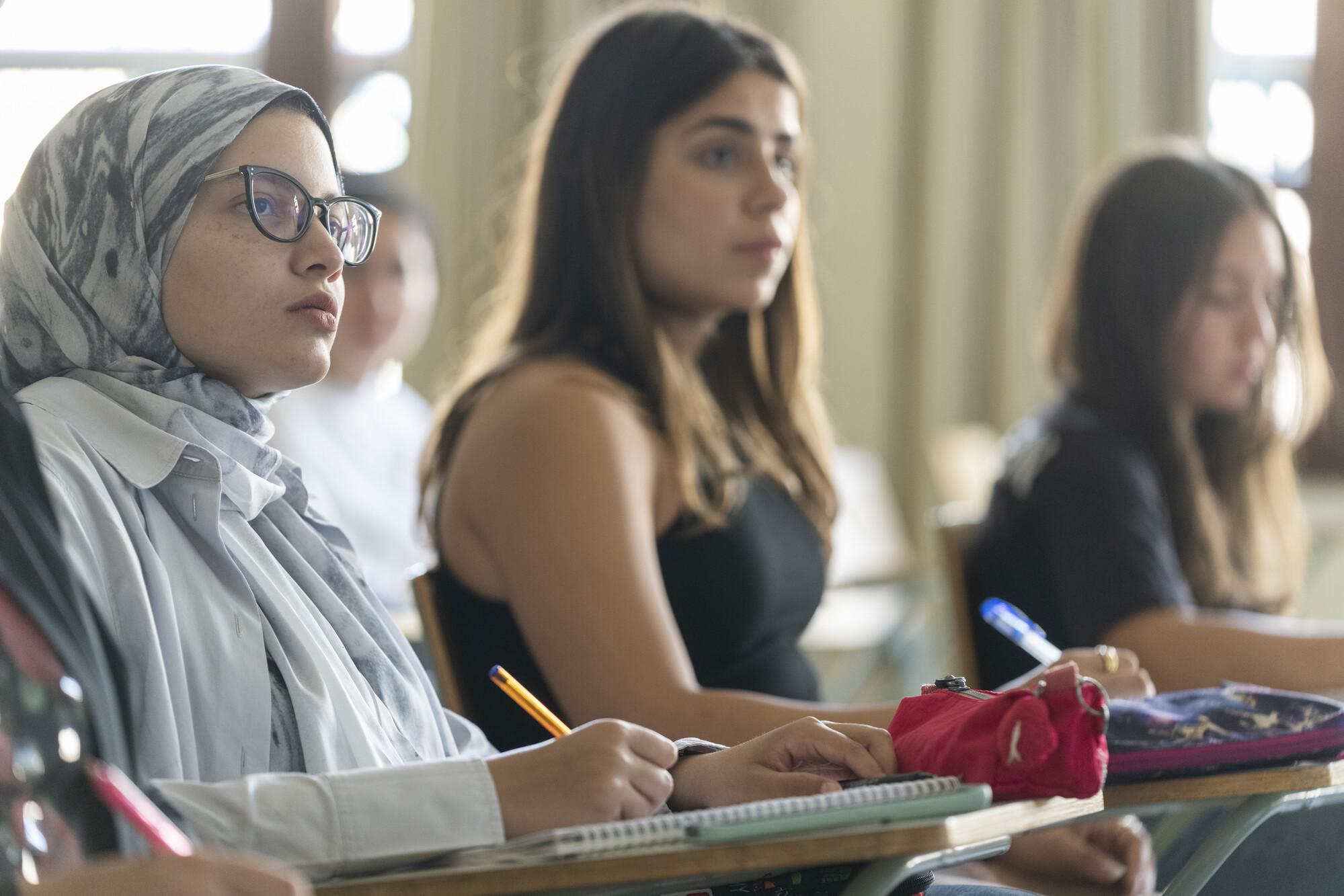 female students focused in class and writing notes 