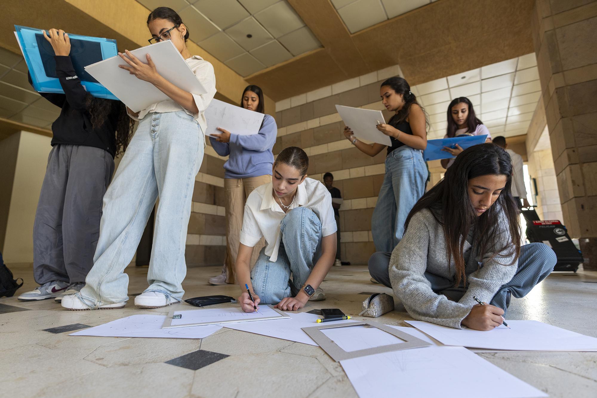 students drawing on campus for a class