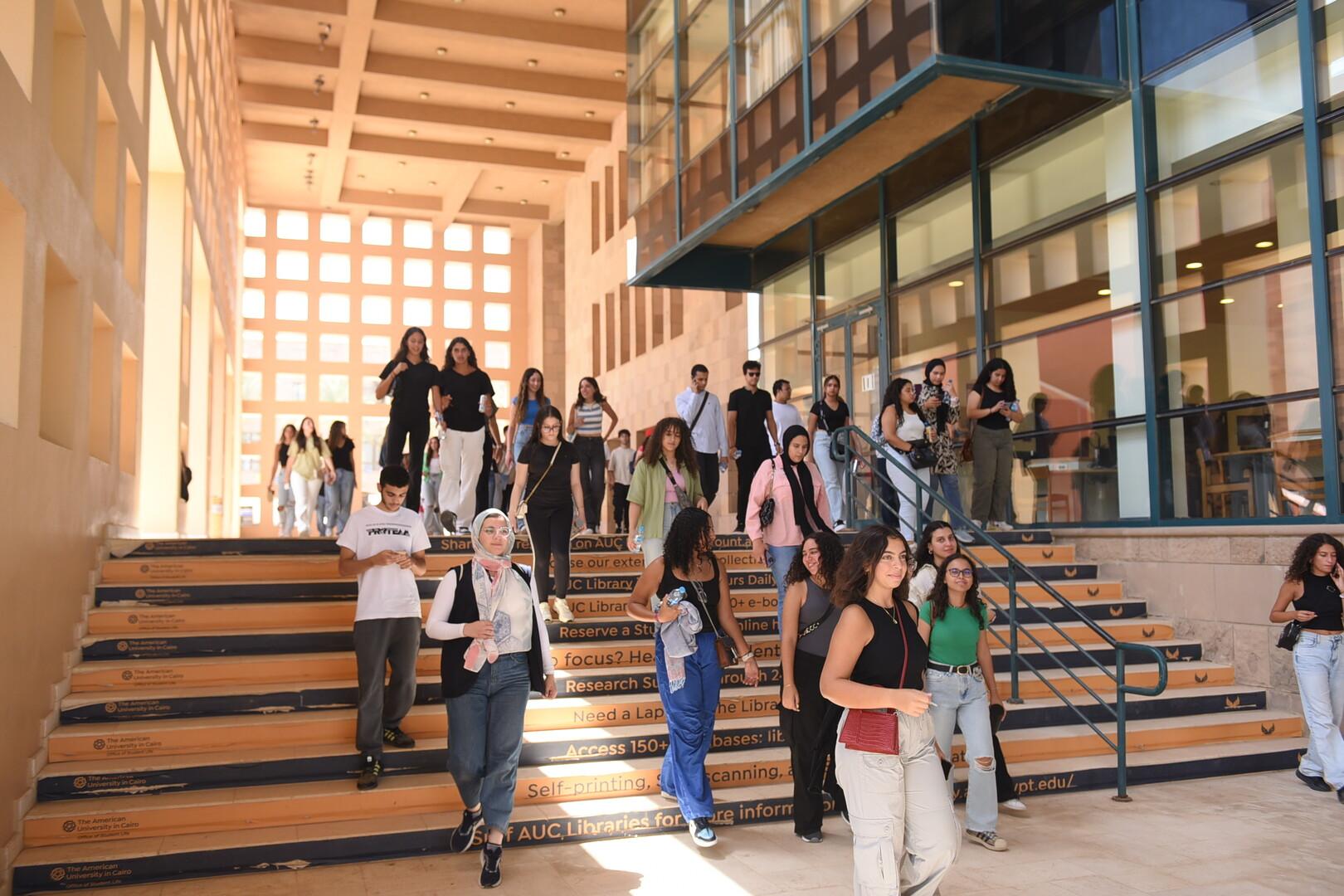 students going up and down the stairs in front of the library