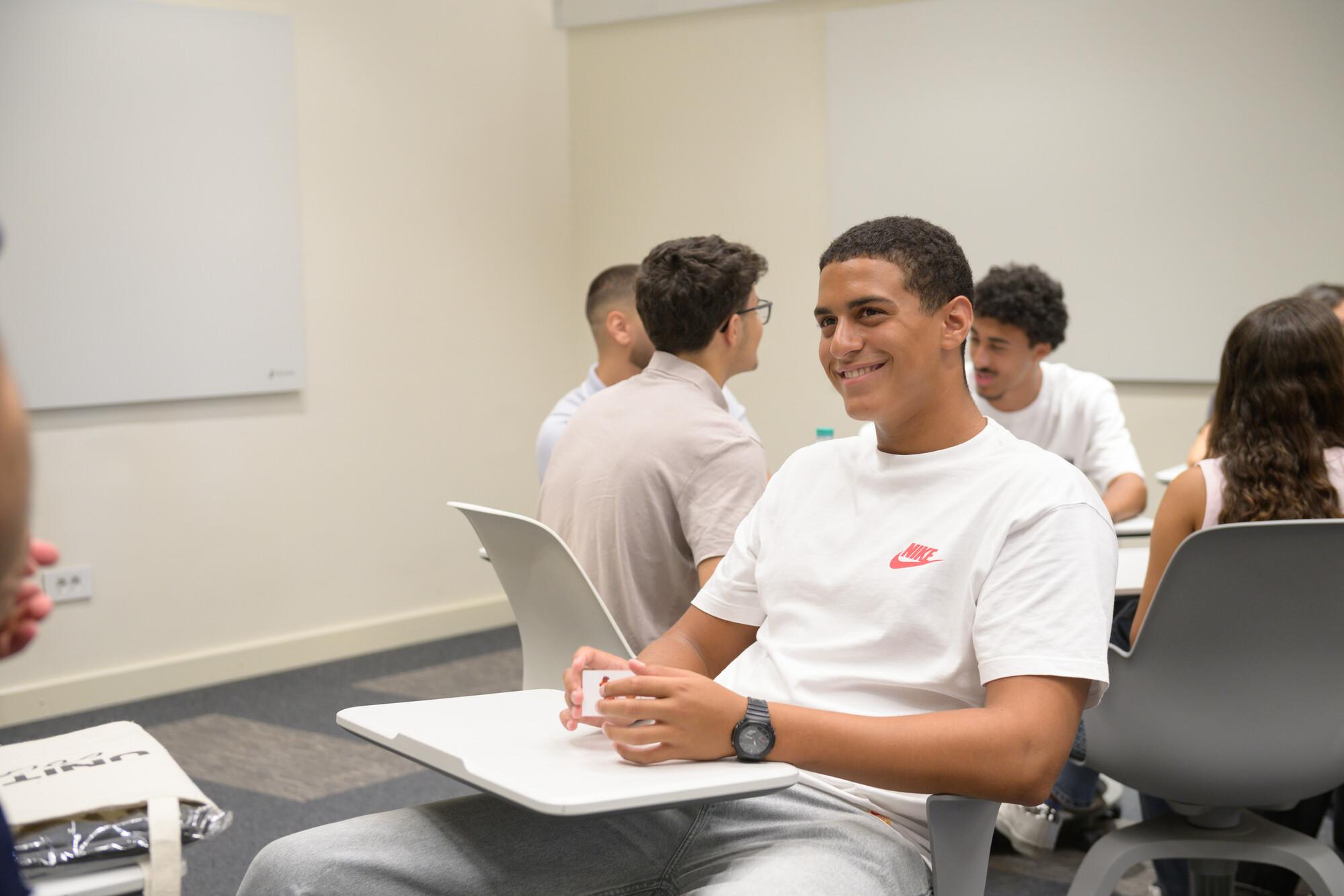 student smiling and participating in class discussion