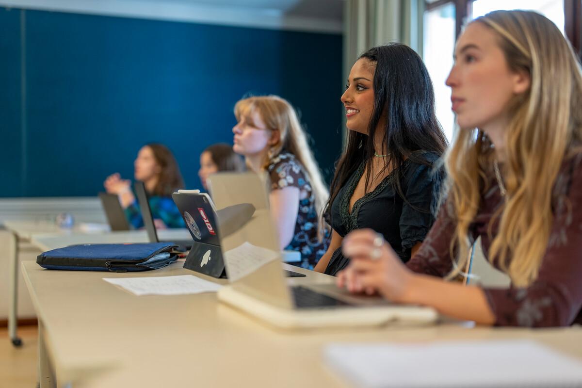 students attending class and taking notes on laptops