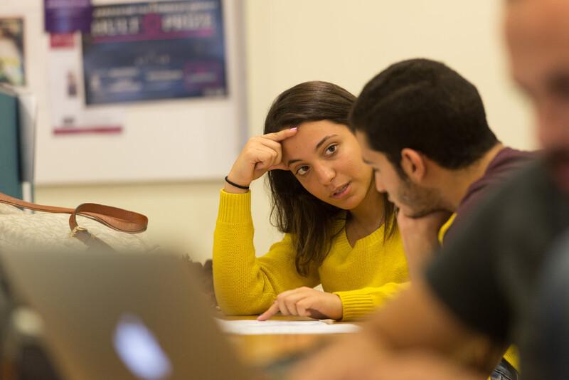 students deep in conversation in a class room setting