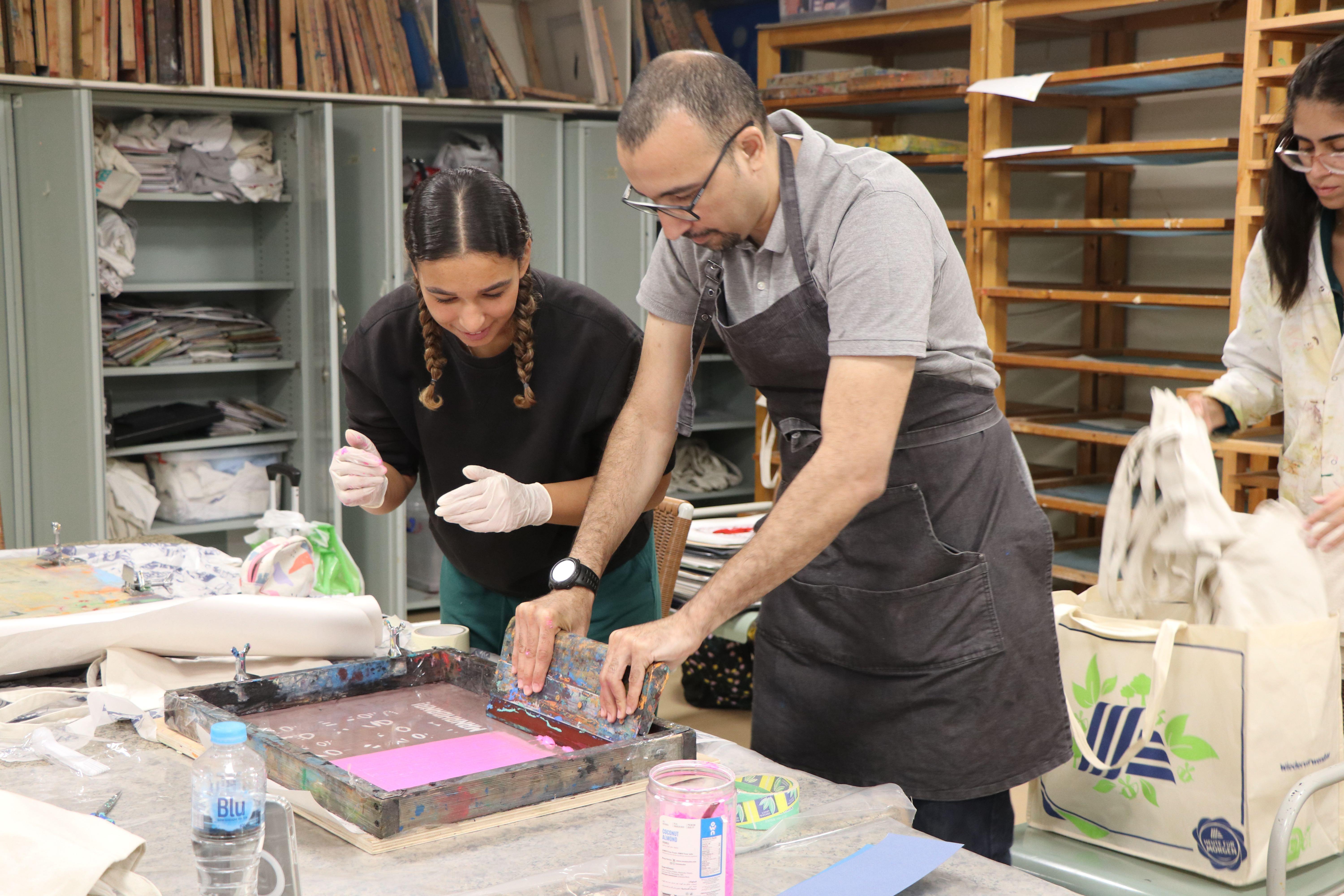 photo of students doing manual printing during a production class