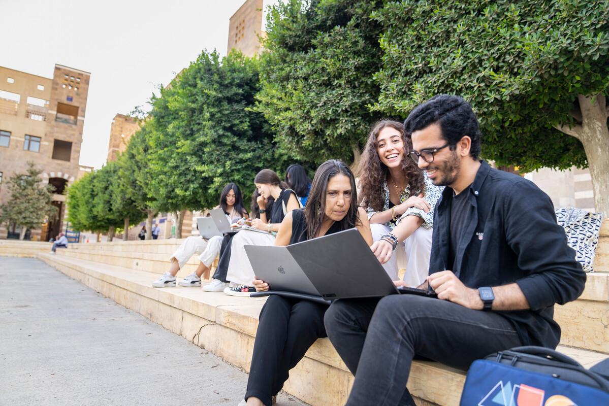 students working with professor outdoors 