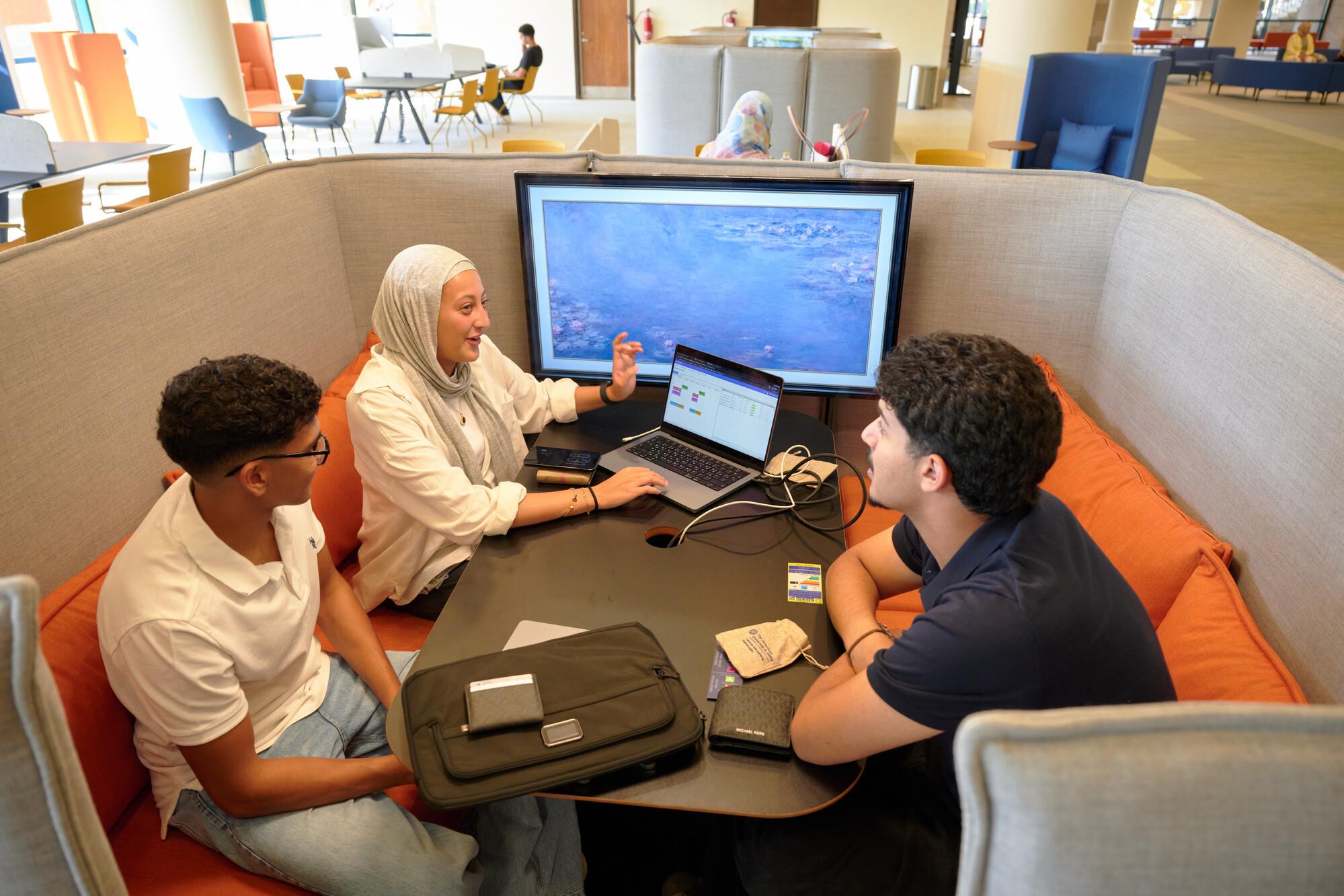 Students working in library and discussing project