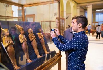 a tourist taking a photo inside the egyptian museum