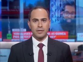 A male is talking, he is wearing a suit and tie