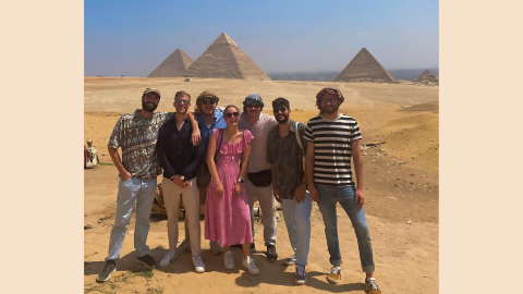 The CMEPS cohort (seven students) smiles in front of the Pyramids of Giza.