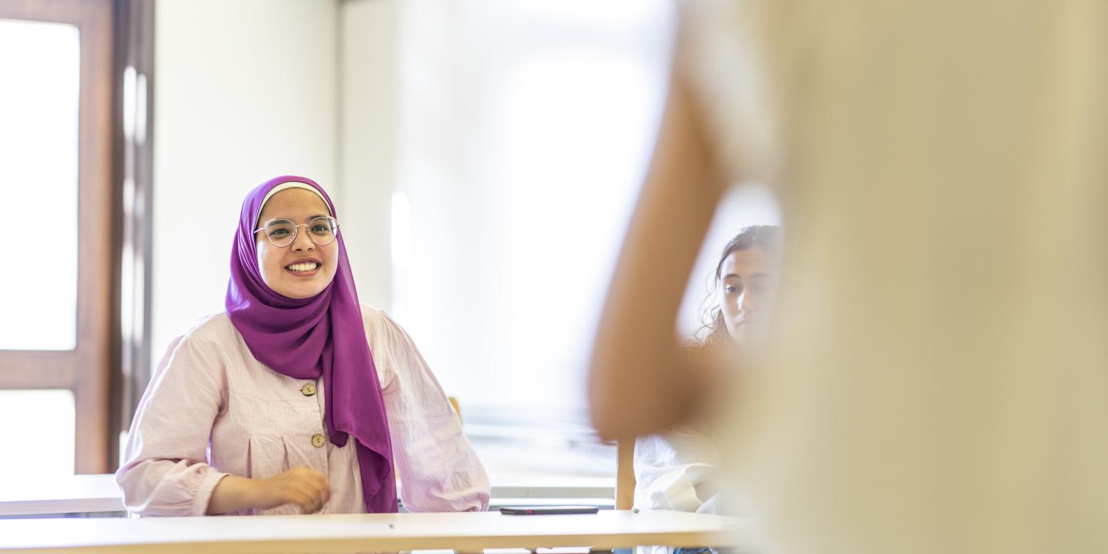 smiling veiled student in class
