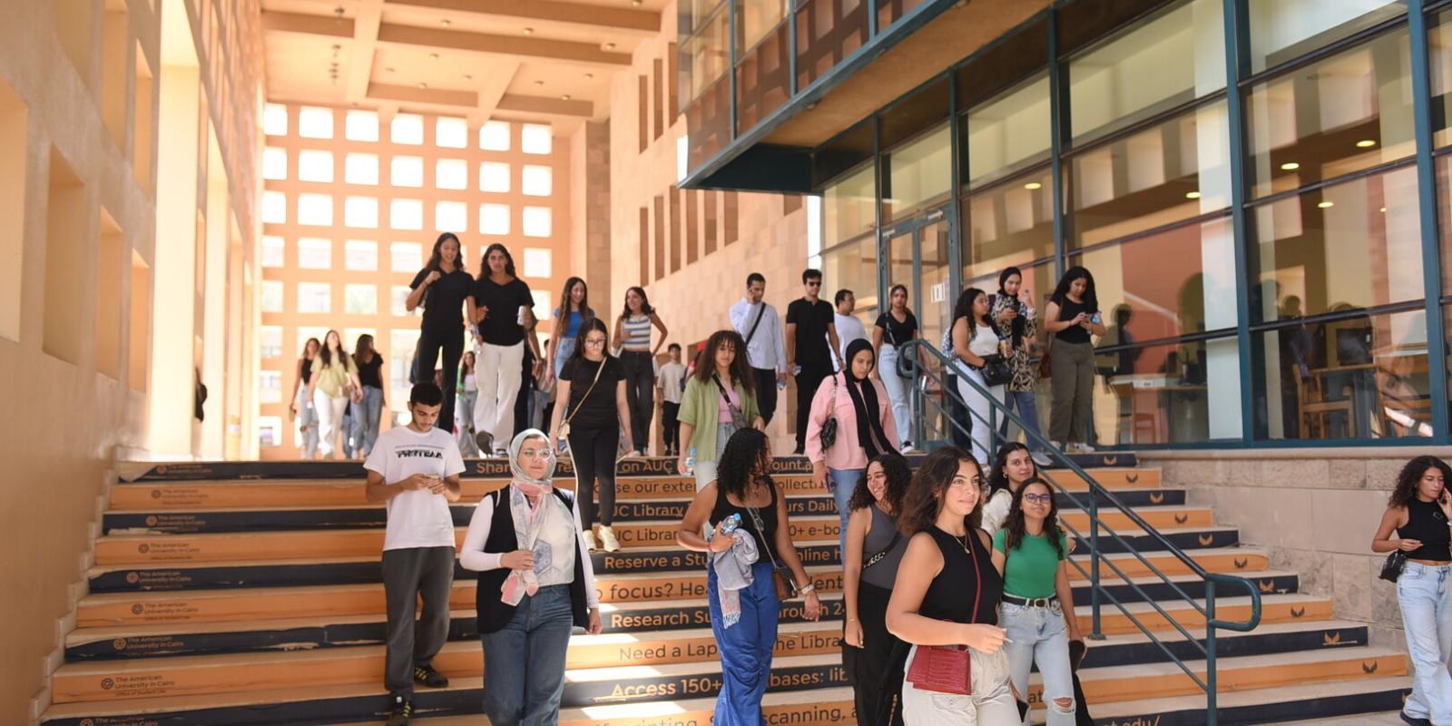 students going down the stairs in front of AUC library