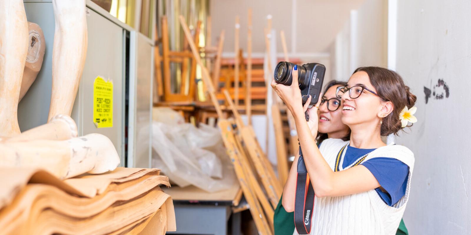 smiling students working with cameras in classroom 