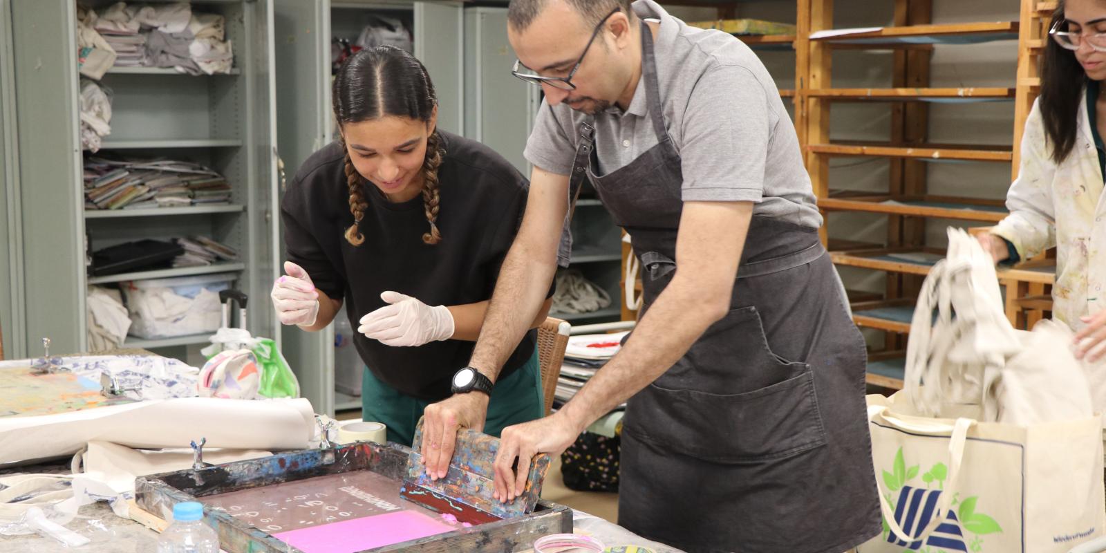 photo of students doing manual printing during a production class