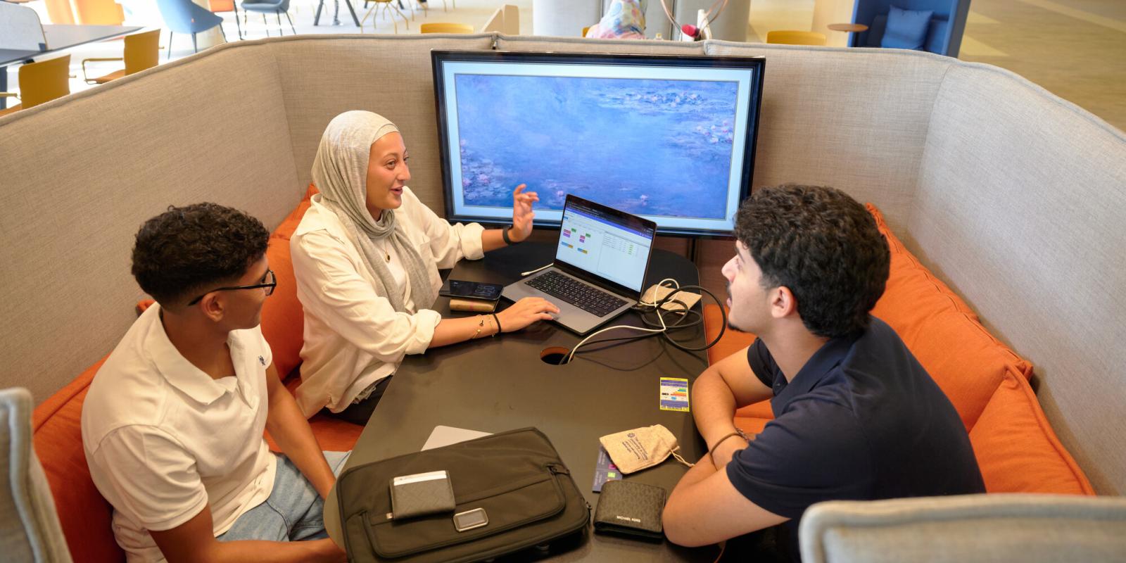 Students working in library and discussing project