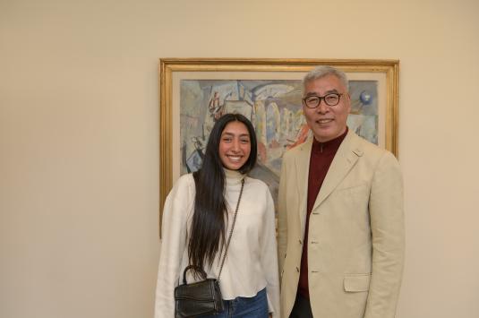 Shahd El Helbawy stands with Wei Liu, smiling in front of a painting.