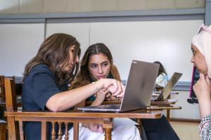 2 students discussing something on a laptop