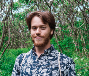 headshot of a boy with trees behind him