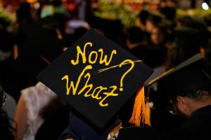 text written on cap of graduation "Now What?"
