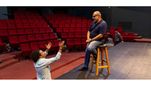 in the theater, an actor emoting to the director