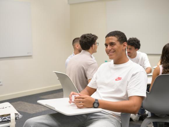 student smiling and participating in class discussion