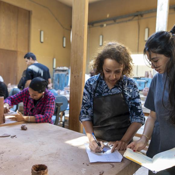 faculty and student working together in a clay studio