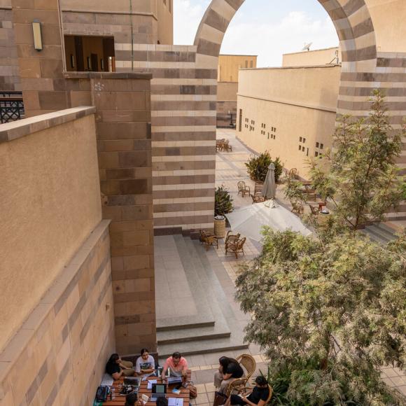 Center for the arts outdoors area where students are sitting and talking together