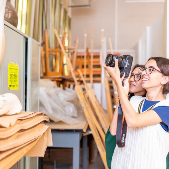 smiling students working with cameras in classroom 