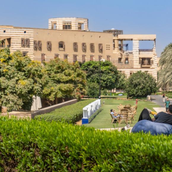 students in auc garden looking at the HUSS building